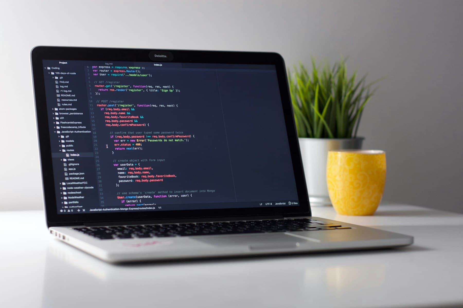 Laptop displaying application source code on a clean desk